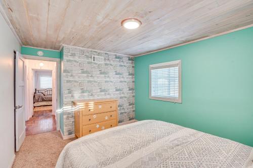 Un dormitorio con una cama y una pared de ladrillo. en Sidney Vacation Rental with Fenced-In Yard!, en Sídney