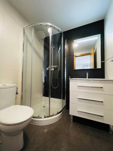 ein Bad mit einem WC und einer Glasdusche in der Unterkunft Apartamento luminoso cerca Salera in Castellón de la Plana