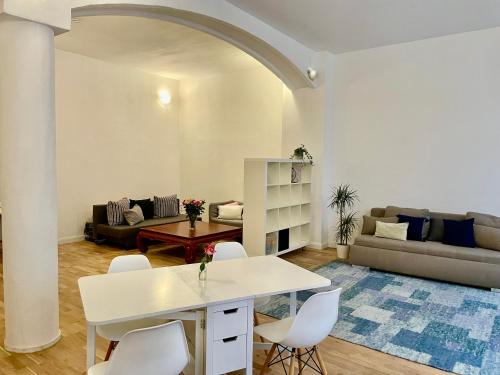 a living room with a white table and chairs at Grindelzimmer in Hamburg