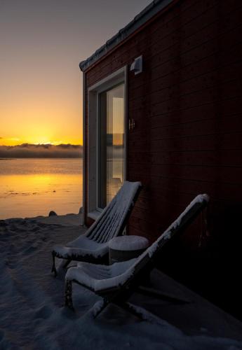 a bench sitting in the snow next to a building at Norwegian Wild in Vangsvik