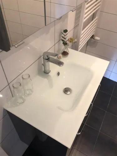 a white sink in a bathroom with two glasses at Kleines gemütliches Studio 1 in Moselnähe in Zeltingen-Rachtig