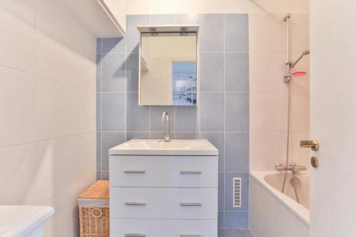 a bathroom with a sink and a mirror and a tub at Avenue Montaigne Paris Bienvenue in Paris