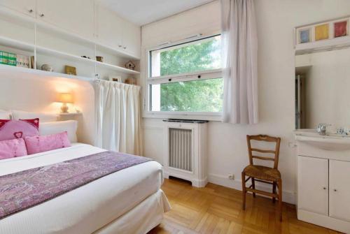 a bedroom with a bed and a sink and a window at Avenue Montaigne Paris Bienvenue in Paris