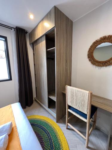 a bedroom with a bed and a desk and a mirror at Yvanka Appart City Antananarive in Antananarivo