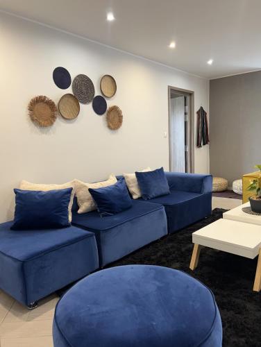 a living room with blue couches and plates on the wall at Yvanka Appart City Antananarive in Antananarivo