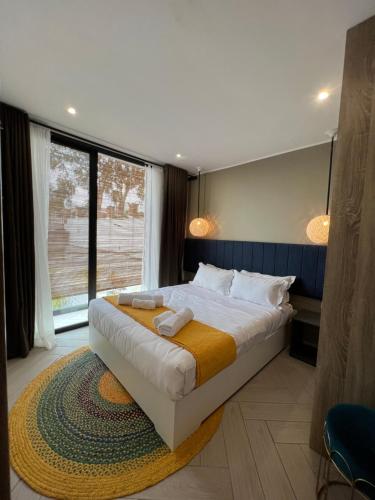 a bedroom with a large bed and a large window at Yvanka Appart City Antananarive in Antananarivo