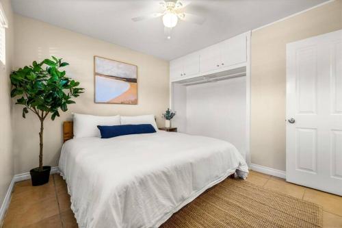 a bedroom with a white bed and a ceiling fan at 2 bedroom with bunk room and private yard for pets in Santa Barbara