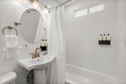 y baño blanco con lavabo y ducha. en 2 bedroom with bunk room and private yard for pets en Santa Bárbara