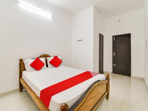 a bedroom with a bed with red pillows on it at OYO Flagship K V R Residency in Yelagiri