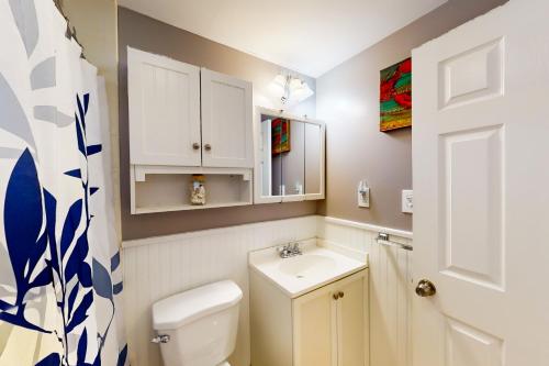 a bathroom with a white toilet and a sink at Sea View Revue - A in Dennis Port