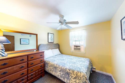 a bedroom with a bed and a dresser with a mirror at Sea View Revue - A in Dennis Port
