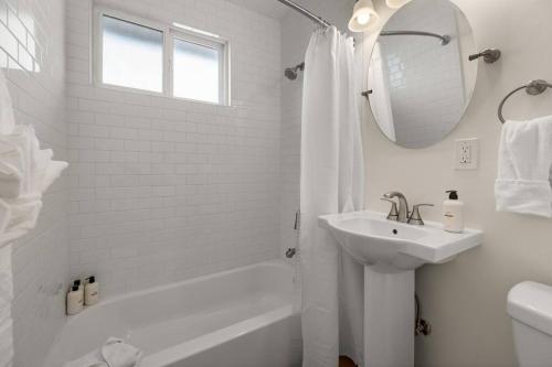 a white bathroom with a sink and a mirror at Downtown apt recently remodeled in Santa Barbara