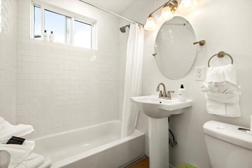a white bathroom with a sink and a mirror at Beach Apartment Walk Downtown in Santa Barbara