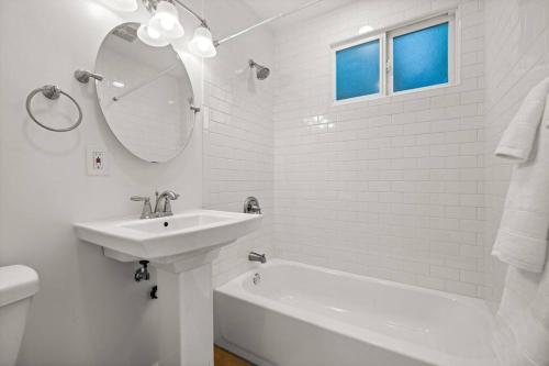 a white bathroom with a sink and a mirror at Funk Zone Apartment Walking Distance to the Beach in Santa Barbara