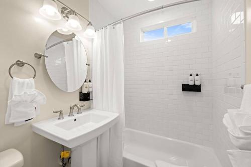 a white bathroom with a sink and a shower at Brand New Apartment Close to Beach and Downtown in Santa Barbara