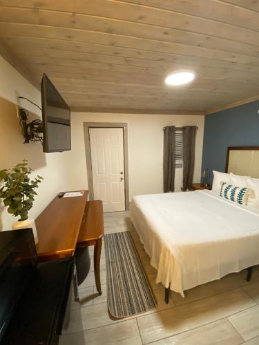 a bedroom with a bed and a desk and a piano at American Inn in Pensacola