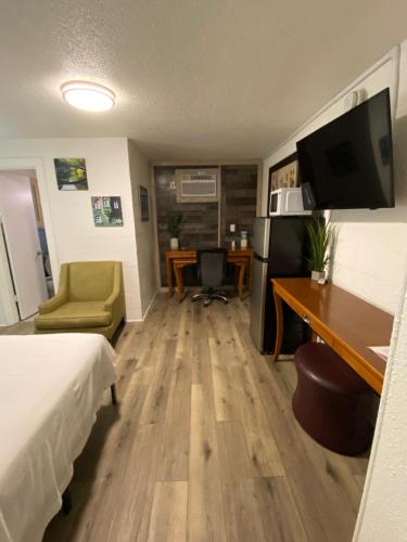 a hotel room with a bed and a desk with a computer at American Inn in Pensacola