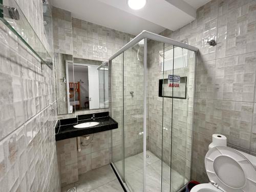 a bathroom with a shower and a toilet and a sink at Pousada Diamante in Ubajara