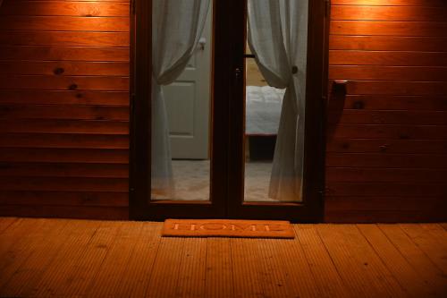 a door with a welcome mat in front of a mirror at Căsuțe în mijlocul naturii - Wild Camp Avrig in Avrig