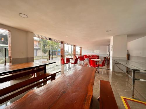 uma grande sala com mesas e cadeiras vermelhas em Pousada Diamante em Ubajara