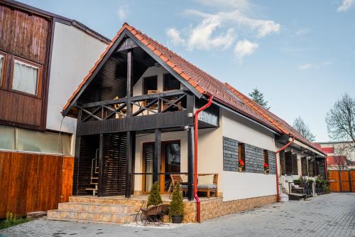 a house with a black and white building at Hanul Anei - entire property in Braşov