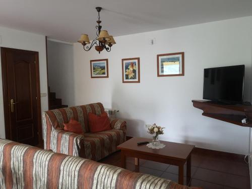 sala de estar con sofá y TV en Viviendas Vacacionales Beni II en Llanes