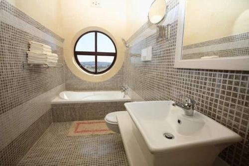 bagno con lavandino, servizi igienici e finestra di 3 Bedroom Farmhouse with Private Pool & Views a Għajnsielem