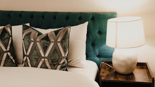 a bedroom with a bed with a lamp on a table at Royal Chambers Serviced Apartments in Glasgow