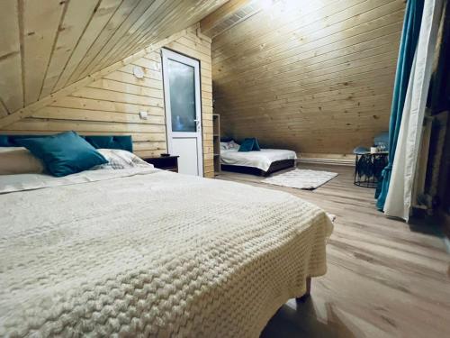 1 dormitorio con 1 cama grande en una habitación de madera en Cabana Loredana, en Vadu Moţilor