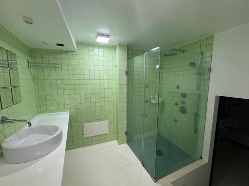 La salle de bains est pourvue d'une douche en verre et d'un lavabo. dans l'établissement Sea Breeze Boutique House, à Porto da Cruz