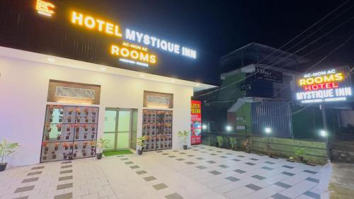 a store with two doors and neon signs on it at Mystique Inn Wayanad in Vythiri