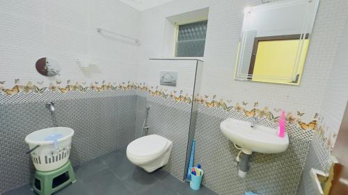 Mystique Inn Wayanad في فيثايراي: حمام مع مرحاض ومغسلة