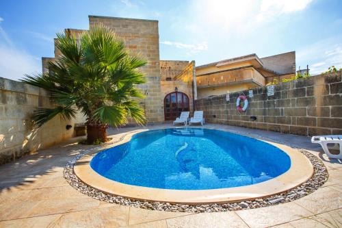 a swimming pool in front of a building at 5 Bedroom Farmhouse with Private Pool & Views in Għarb