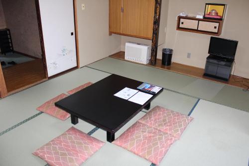 a living room with a table and two mats at Yamadaya Hotel in Fujikawaguchiko