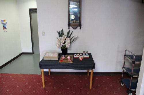 a table in a room with a vase of flowers at Yamadaya Hotel in Fujikawaguchiko