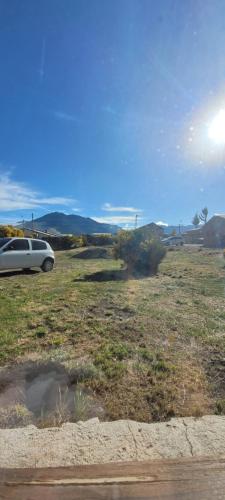 a car parked in a field next to a puddle at El Retamo in San Carlos de Bariloche
