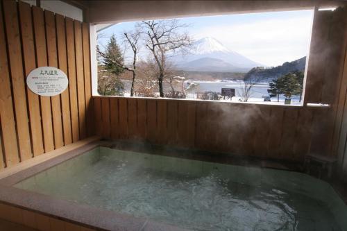 a jacuzzi tub with a view of a mountain at Yamadaya Hotel in Fujikawaguchiko