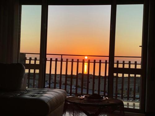 a room with a couch and a view of the sunset at Un Letto sul Mare (vit vit vit) in Marsala