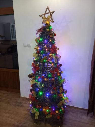 a christmas tree decorated with lights and a star at Къща за гости Куклите Петревене in Petrevene
