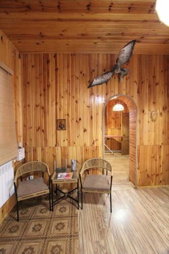 a room with two chairs and a bird on the wall at Cottage "Lure" in Yaremche