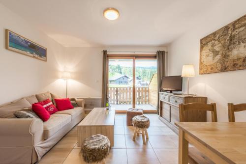 un salon avec un canapé et une table dans l'établissement L'Eden Ski aux Pieds, à Morillon