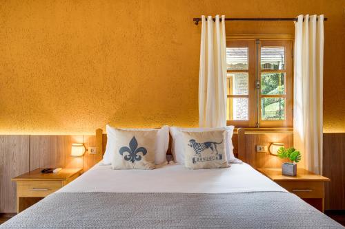 um quarto com uma cama com almofadas e uma janela em Pousada Jardim Monte Verde em Monte Verde