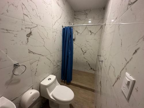 uma casa de banho com um WC e uma cortina de chuveiro azul em Villa Verona em Guatemala