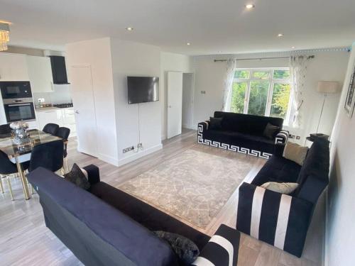 a living room with two couches and a kitchen at Watford cottage holiday house in Abbots Langley