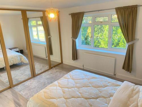 a bedroom with a large mirror in front of a bed at Watford cottage holiday house in Abbots Langley