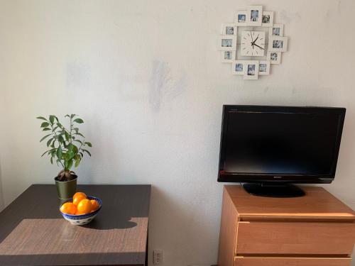 a television and a bowl of oranges on a table at Pokój dwuosobowy w Wilanowie in Warsaw