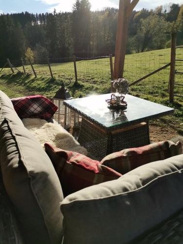 a living room with a couch and a table in a field at Landhaus Schusterfranz in Oberneudorf