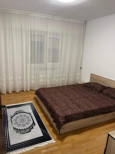 a bedroom with a bed and a large window at Apartament Central in Tulcea