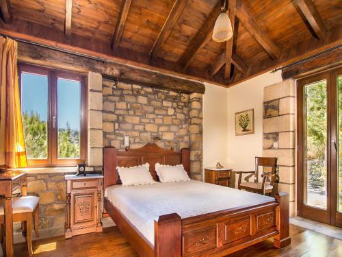a bedroom with a bed and a stone wall at Falasarna Villas in Falasarna