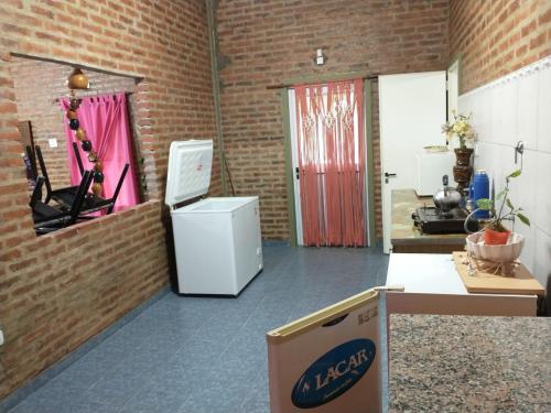 Cette chambre dispose d'un réfrigérateur et d'un mur en briques. dans l'établissement Casa quinta vuelta de obligado, à Vuelta de Obligado